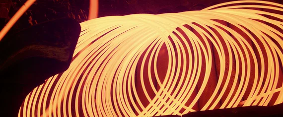 Un fil incandescent est transformé en spirales orange vif à haute température dans un four industriel.