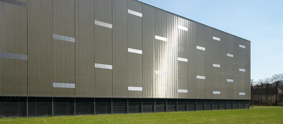 Semi-transparent architectural mesh façade with a textured metal design
