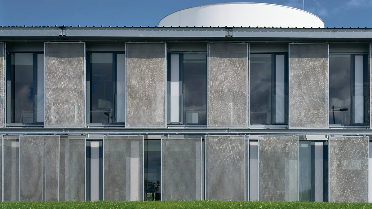 Cadres de toile orientables en toile d’acier inoxydable utilisés en façade en guise de protection solaire.