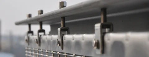 Top fixing solution for wire cloth façades with flat screen hook and clevis screws