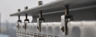 Top fixing solution for wire cloth façades with flat screen hook and clevis screws