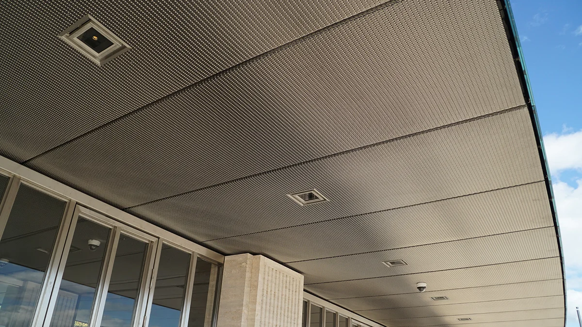 Ceiling covering made out of a dense stainless steel wire mesh with gaps for integration of lighting.