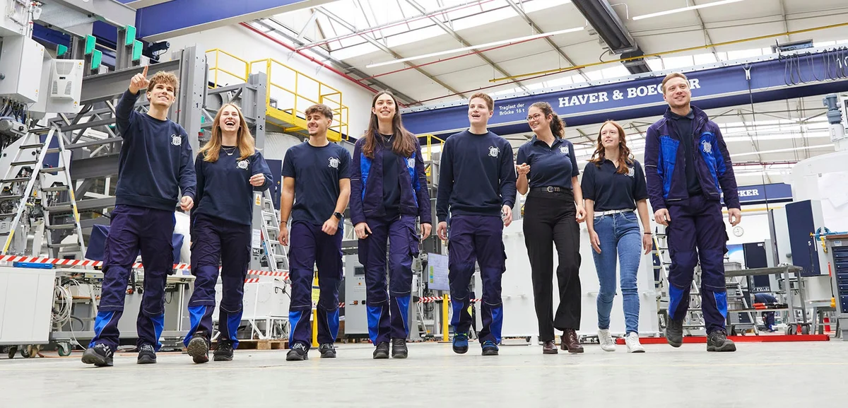 Eight trainees walk through the production hall with anticipation.