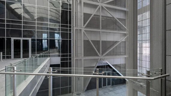 A view of a cross-storey wall covering made out of stainless steel wire mesh.