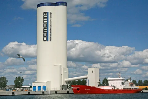 An einem Zementterminal mit einem Mehrkammersilo und Losebeladung für LKW und Waggons wird ein Zementschiff beladen.