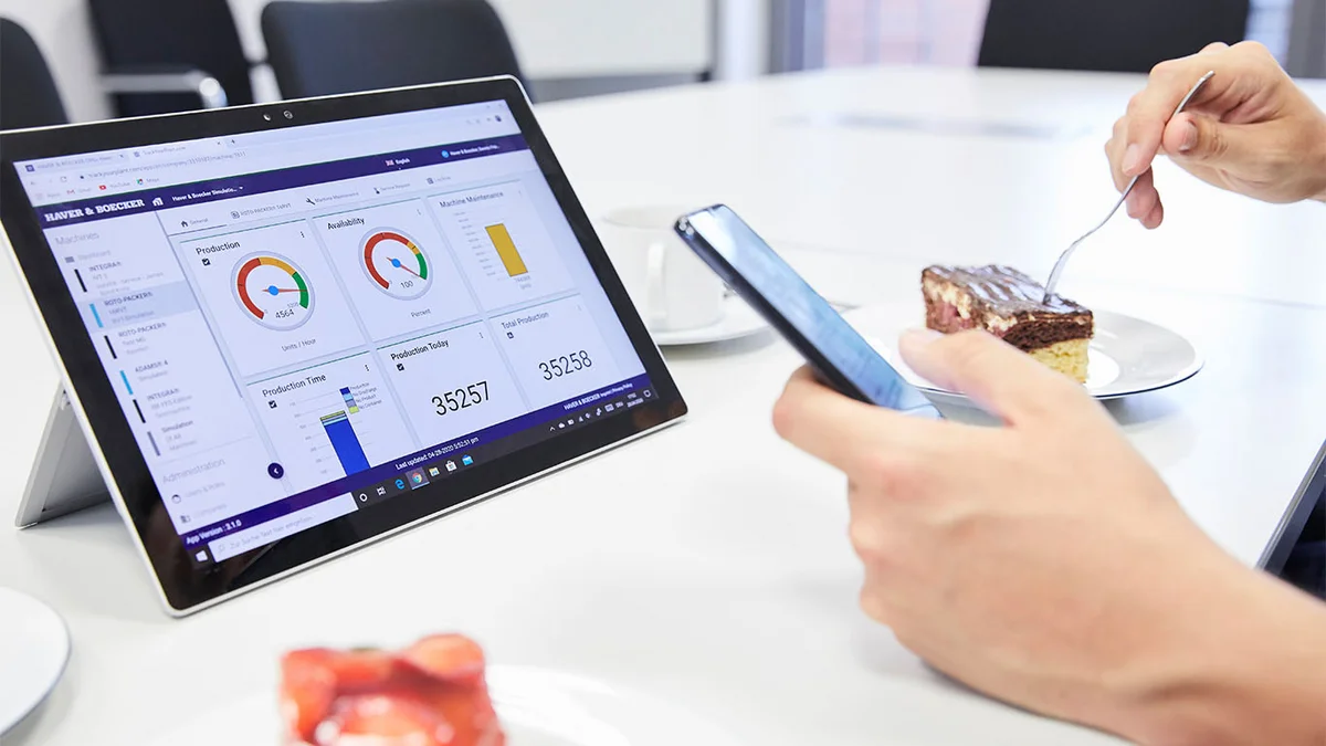Person überwacht Anlagen-Leistungsdaten auf Handy und Tablet.