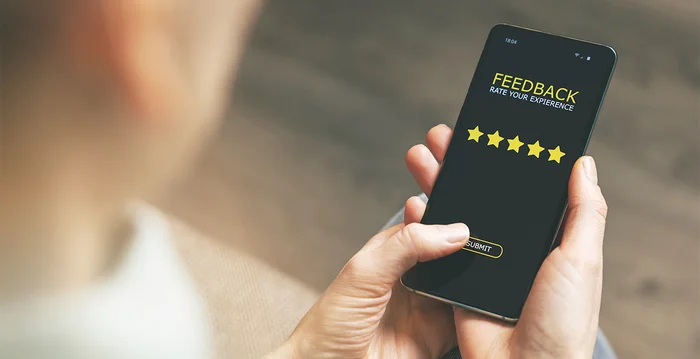 Eine Person schaut auf ihr Smartphone und gibt ein Feedback ab.