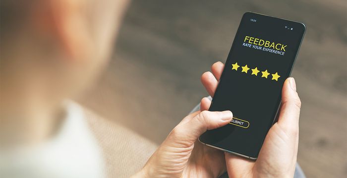 Eine Person schaut auf ihr Smartphone und gibt ein Feedback ab.