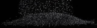 Black plastic granules fall in an arc and form a pile against a black background, a symbolic image for plastics engineering.