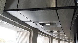 Wall and ceiling covering made out of shiny stainless steel wire mesh fabric with integrated ceiling lighting.