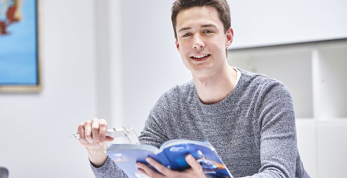 Ein angehender technischer Produktdesigner liest Daten in einem Buch nach.