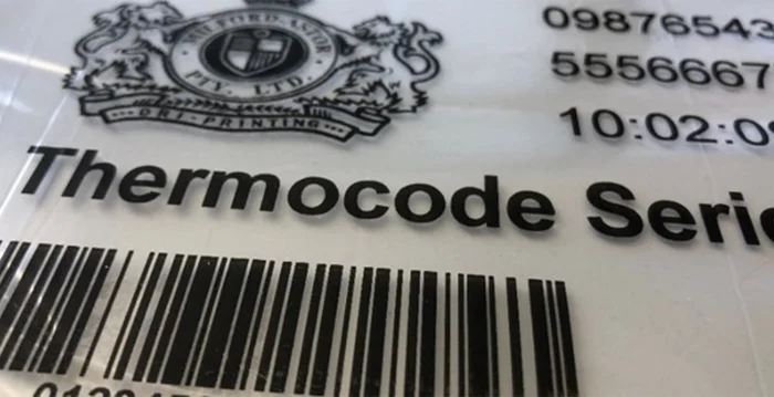 Auf einer weißen Verpackung sind ein detailreiches Wappen, Artikelnummern, Zeitstempel und Barcode in verschiedenen Schriftgrößen schwarz aufgedruckt.