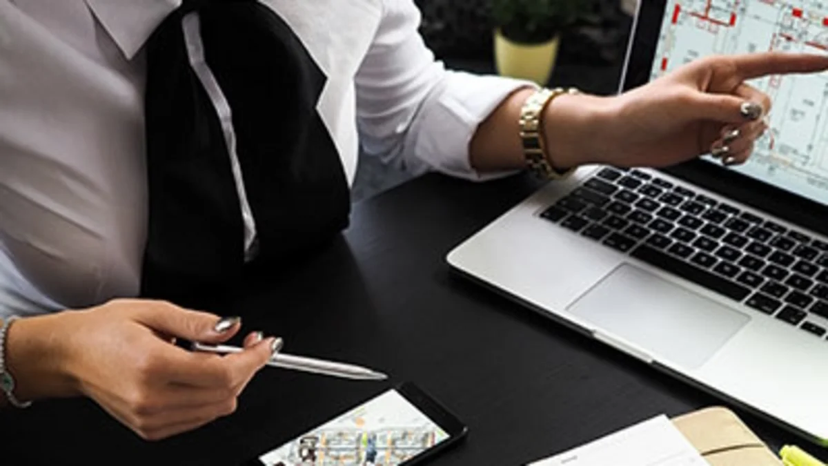 Projektmanager analysiert technische Pläne am Laptop während der Projektbesprechung