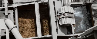 Haver & Boecker Brasil's industrial screening machine mechanically sorts raw materials in a metal grid system.