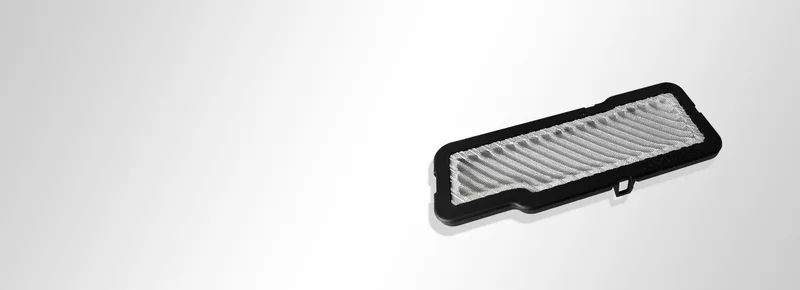 Pièce en tissu avec surmoulage en plastique et toile métallique plissée