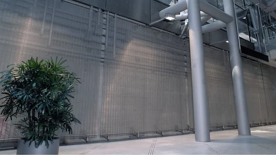 Wall with architectural wire mesh to protect technical equipment.