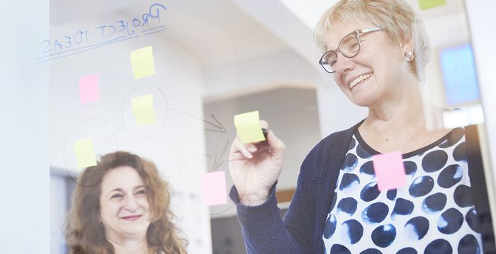 Ein Team aus zwei Personen lacht während der Arbeit.