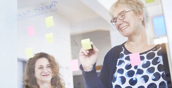 Ein Team aus zwei Personen lacht während der Arbeit.