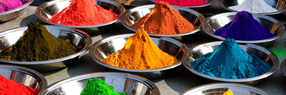 Multiple containers filled with various pigment powders — ideal candidates for hybrid FFS packing using HAVER & BOECKER ADAMS® technology