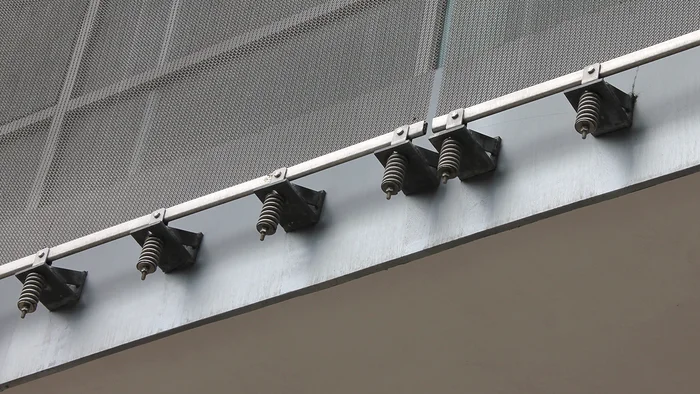 Revêtement de façade en toile pour l’architecture avec une ossature ponctuelle constituée de sangles de retenue.