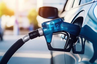 Nahaufnahme eines Brennstoffzellenfahrzeugs mit angeschlossenem Wasserstoff-Zapfhahn.