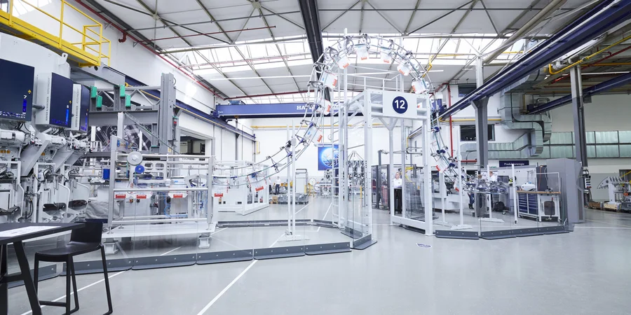 Automated cement packaging line with HAVER & BOECKER PATHFINDER bag transport system in a modern plant, showing efficient empty bag logistics and packaging automation for cement production.