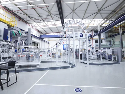 Automated cement packaging line with HAVER & BOECKER PATHFINDER bag transport system in a modern plant, showing efficient empty bag logistics and packaging automation for cement production.