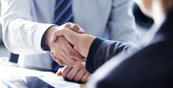 Zwei Personen reichen sich die Hand.