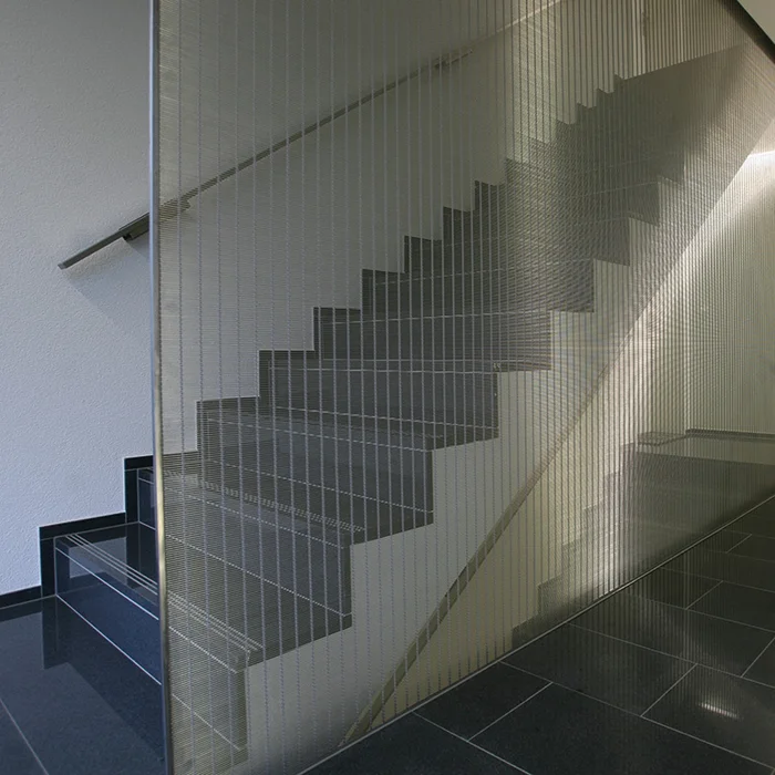 Staircase cladding: Shimmering eye-catcher and fall protection at the same time with wire mesh cladding made of MULTI-BARRETTE.
