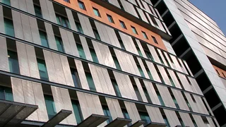 Glänzende Sonnenschutzfassade aus Architekturgewebe