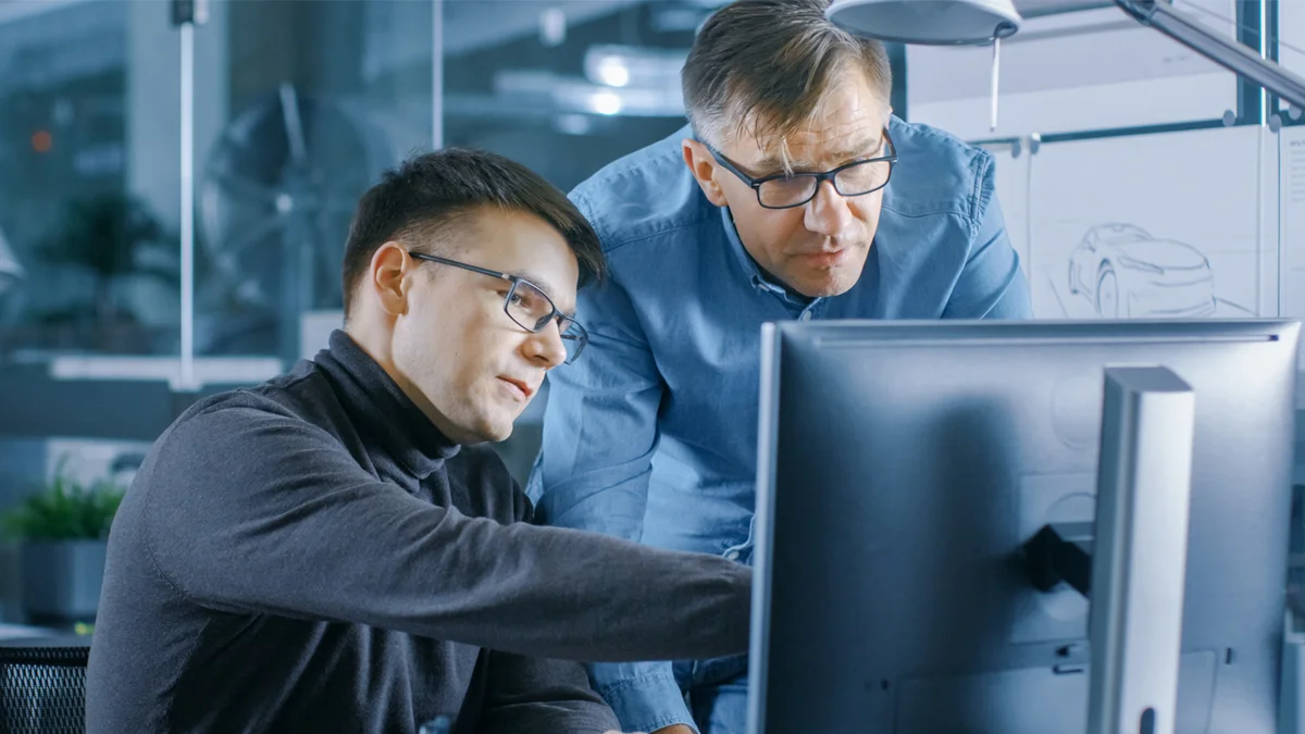 Un employé montre des prototypes de pièces façonnées sur PC