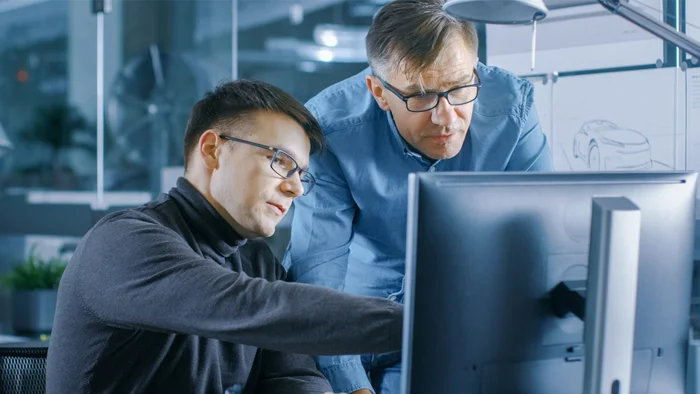 Un employé montre des prototypes de pièces façonnées sur PC