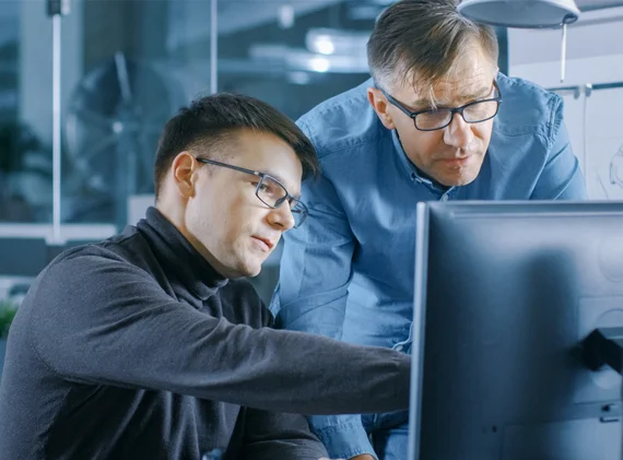 Mitarbeiter zeigt Prototypen von Formteilen am PC