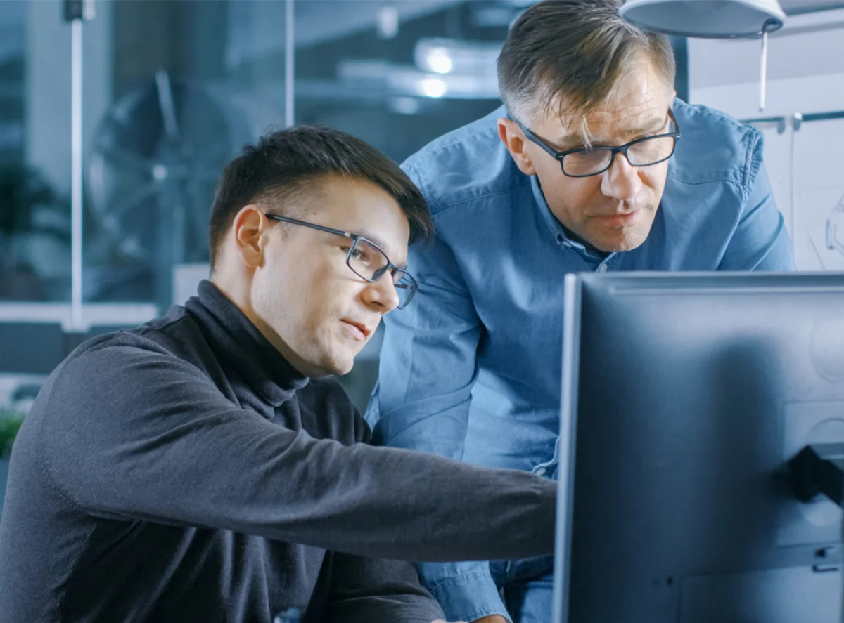 Mitarbeiter zeigt Prototypen von Formteilen am PC
