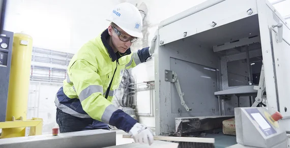 Technicien de service nettoyant une bande transporteuse