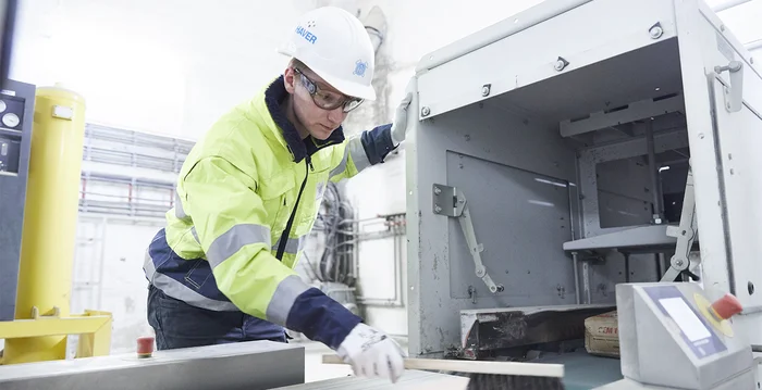Technicien de service nettoyant une bande transporteuse