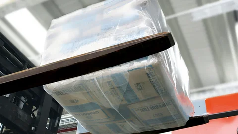 Ein palettenloser Stapel mit Zementsäcken wird vom Palettierer abtransportiert.