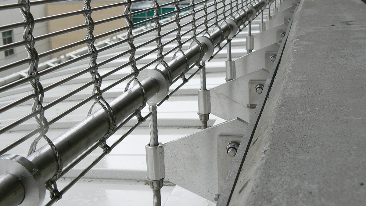 Sangles de retenue ponctuelles comme ossature d’un revêtement de façade en toile métallique.