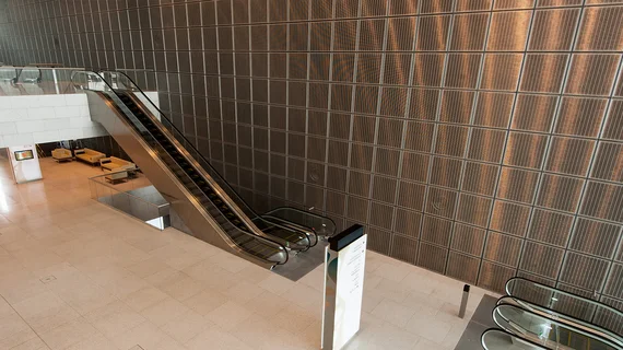 Shiny wall covering made out of quadratic frame elements with stainless steel wire mesh.