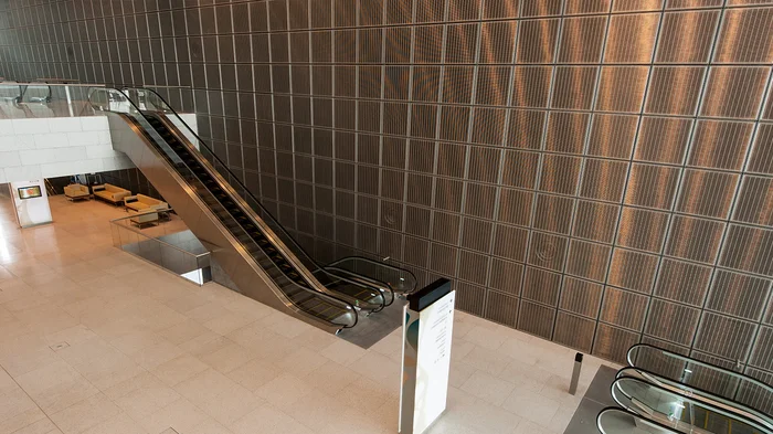 Shiny wall covering made out of quadratic frame elements with stainless steel wire mesh.