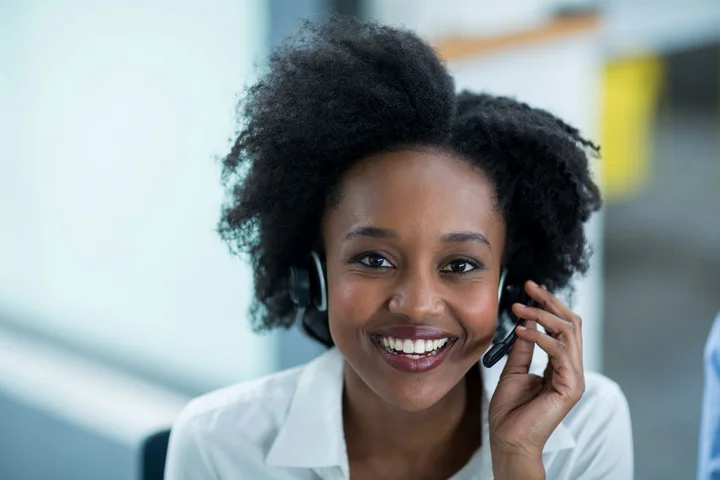 Eine Frau mit Headset nimmt einen Hotline-Anruf entgegen.