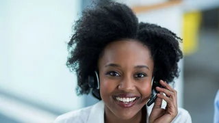 Eine Frau mit Headset nimmt einen Hotline-Anruf entgegen.