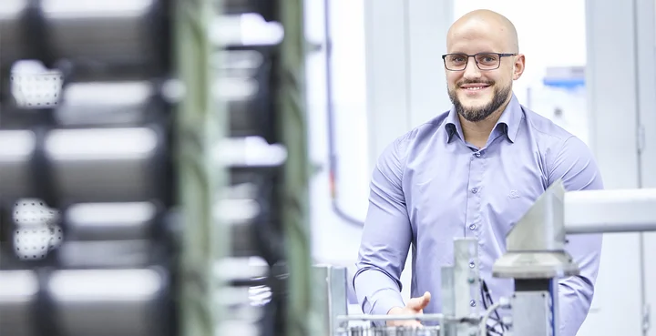 A young professional stands at his new workplace. 