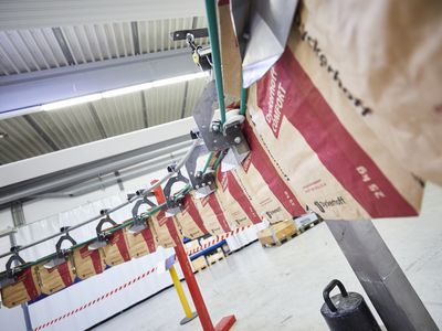 HAVER & BOECKER PATHFINDER automated bag handling system transferring empty bags from RADIMAT to ROTO-PACKER in a fully automated packing line