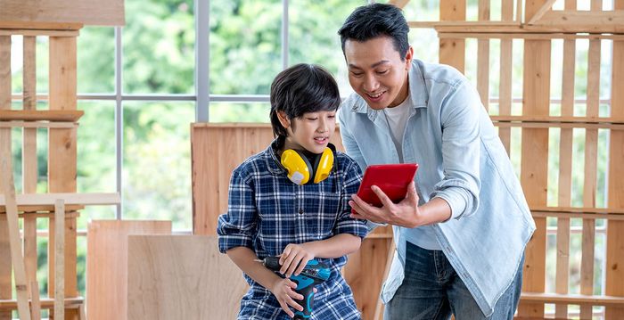 Ein Mann zeigt seinem Sohn ein neues Konzept auf seinem Tablet