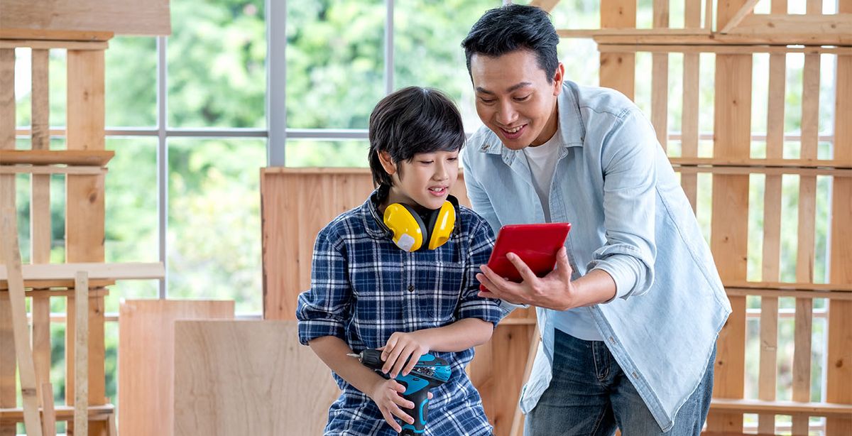 Ein Mann zeigt seinem Sohn ein neues Konzept auf seinem Tablet