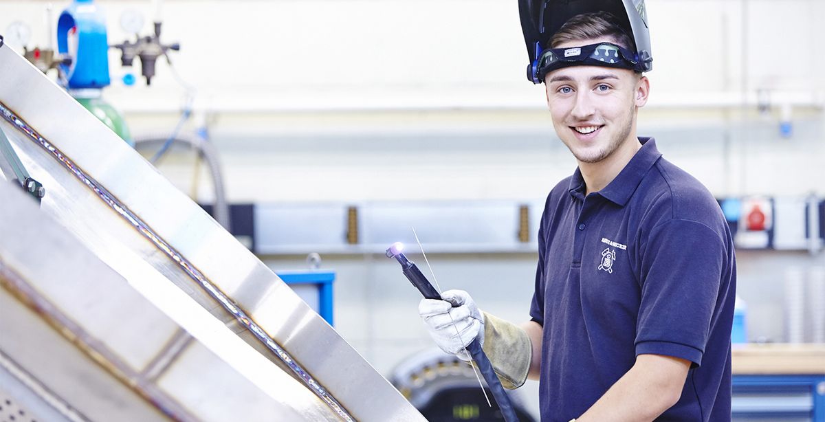 Ein angehender Industriemechaniker repariert eine Anlage der Drahtweberei.