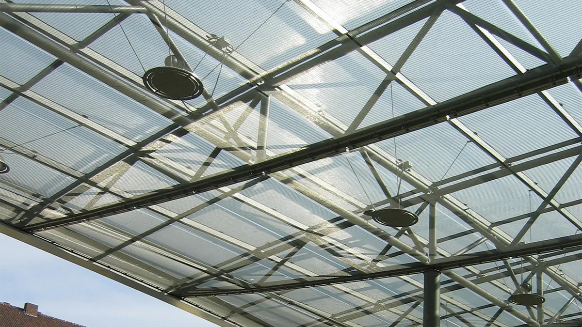 Ouvertures pour lampes dans les panneaux en toile métallique tendue d’un revêtement de plafond.