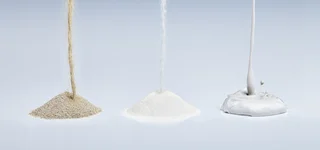 Drei verschiedene Baustoffe rieseln und fließen herab