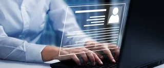 Mitarbeiter in weißem Hemd tippt auf Laptop und füllt digitales Online-Formular mit persönlichen Daten aus, Symbolbild für Registrierung.